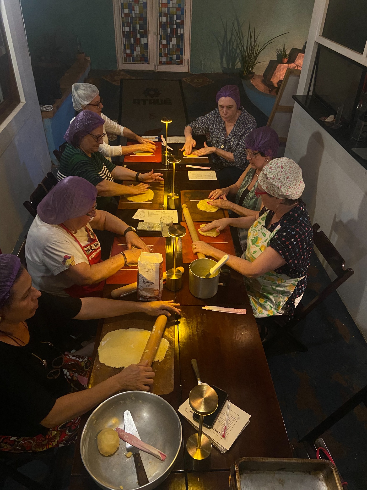 Participantes preparando biscoitos em uma mesa coletiva