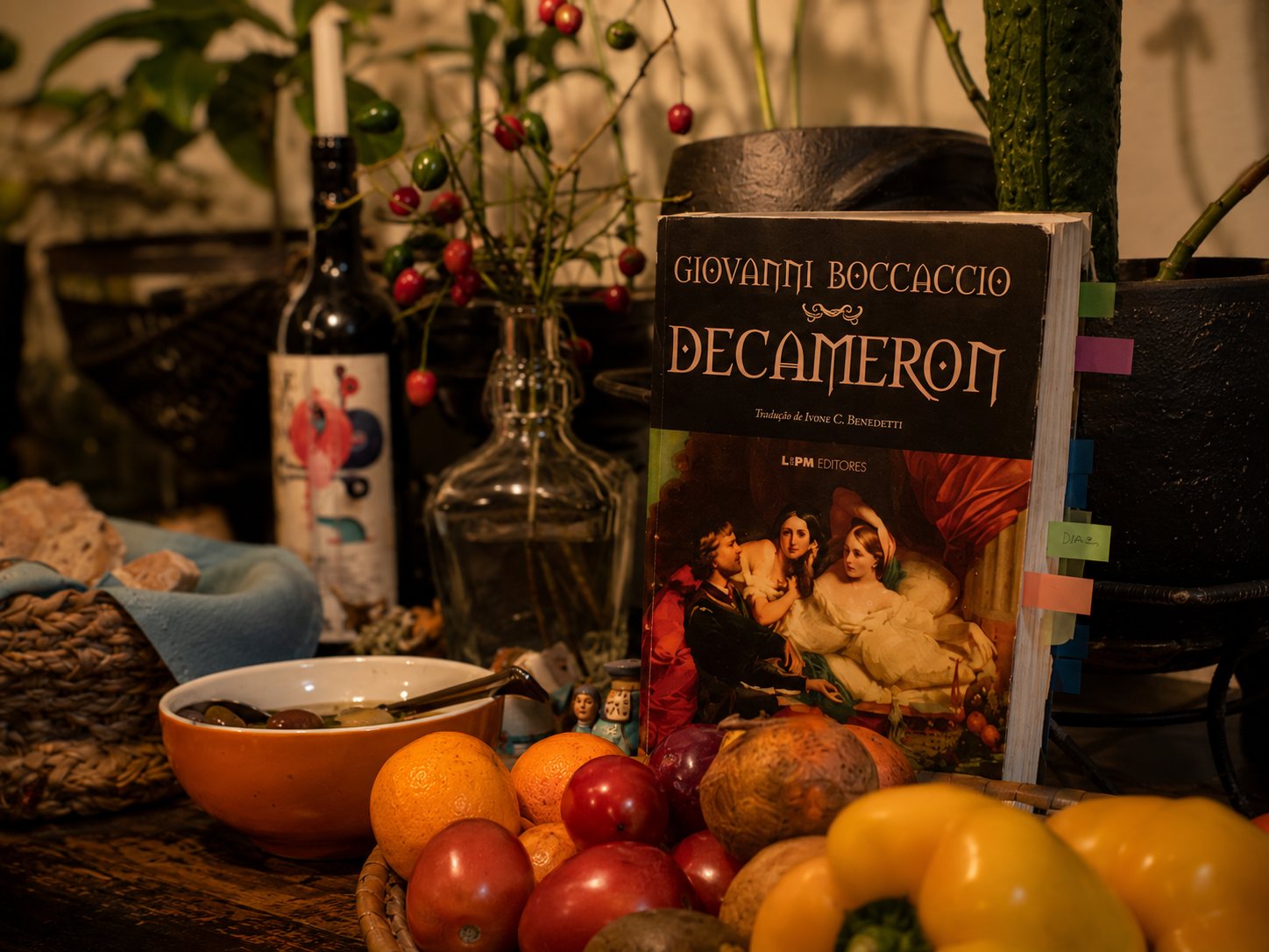 Livro Decameron entre frutas e elementos de mesa