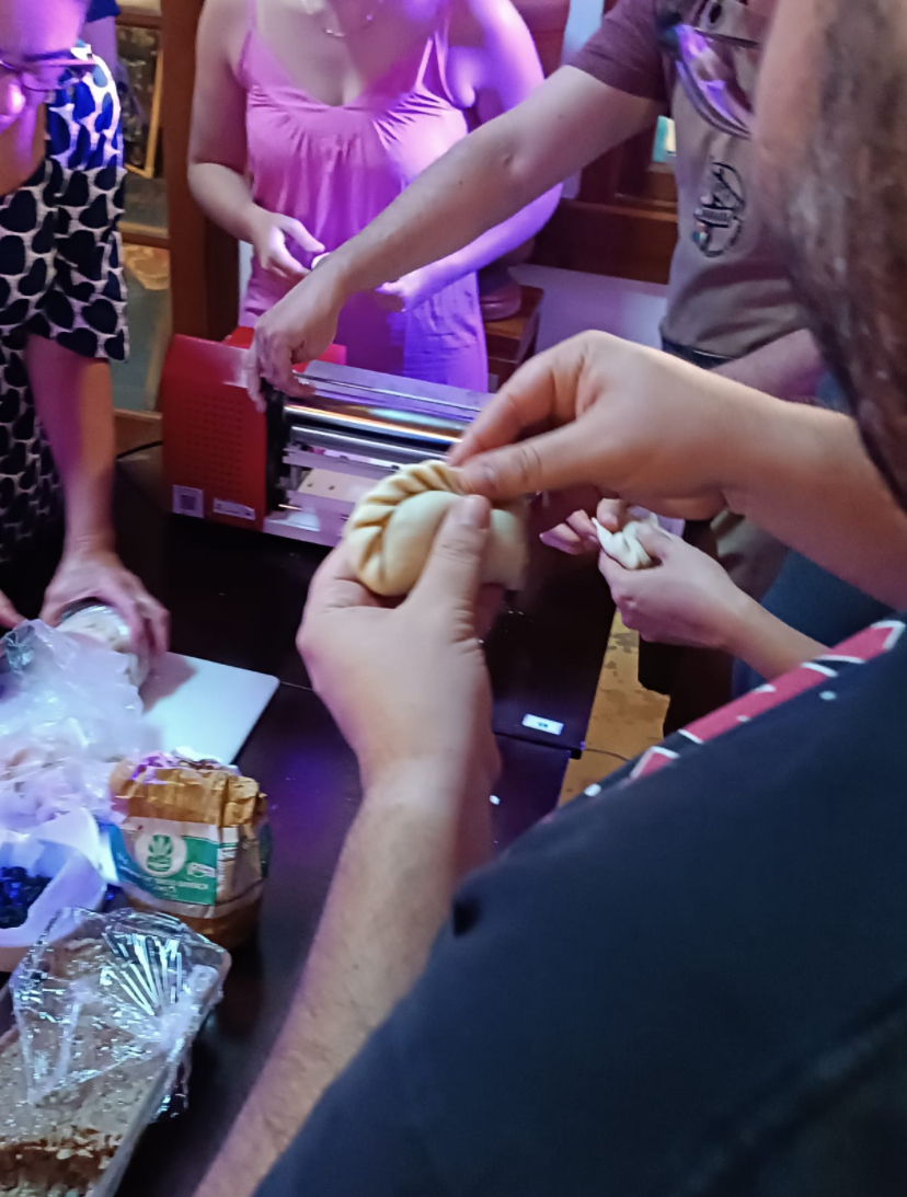 Participante fechando e modelando uma empanada