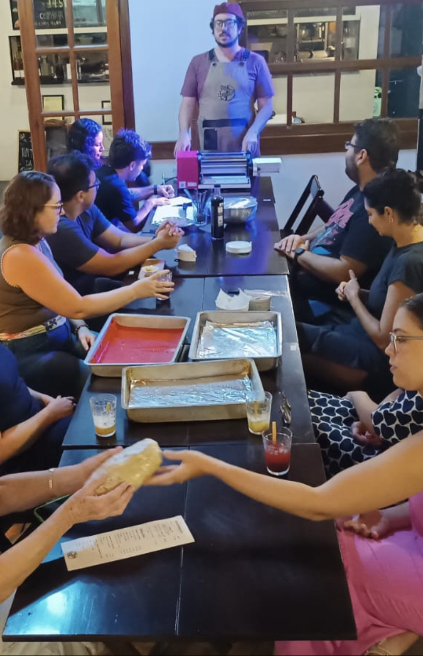 Grupo reunido em torno da mesa durante o Cozinhando Juntos: Empanadas