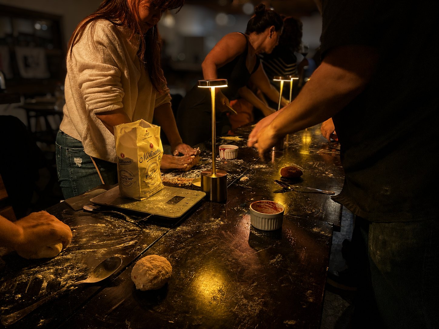 Participantes preparando massa fresca em uma bancada coletiva