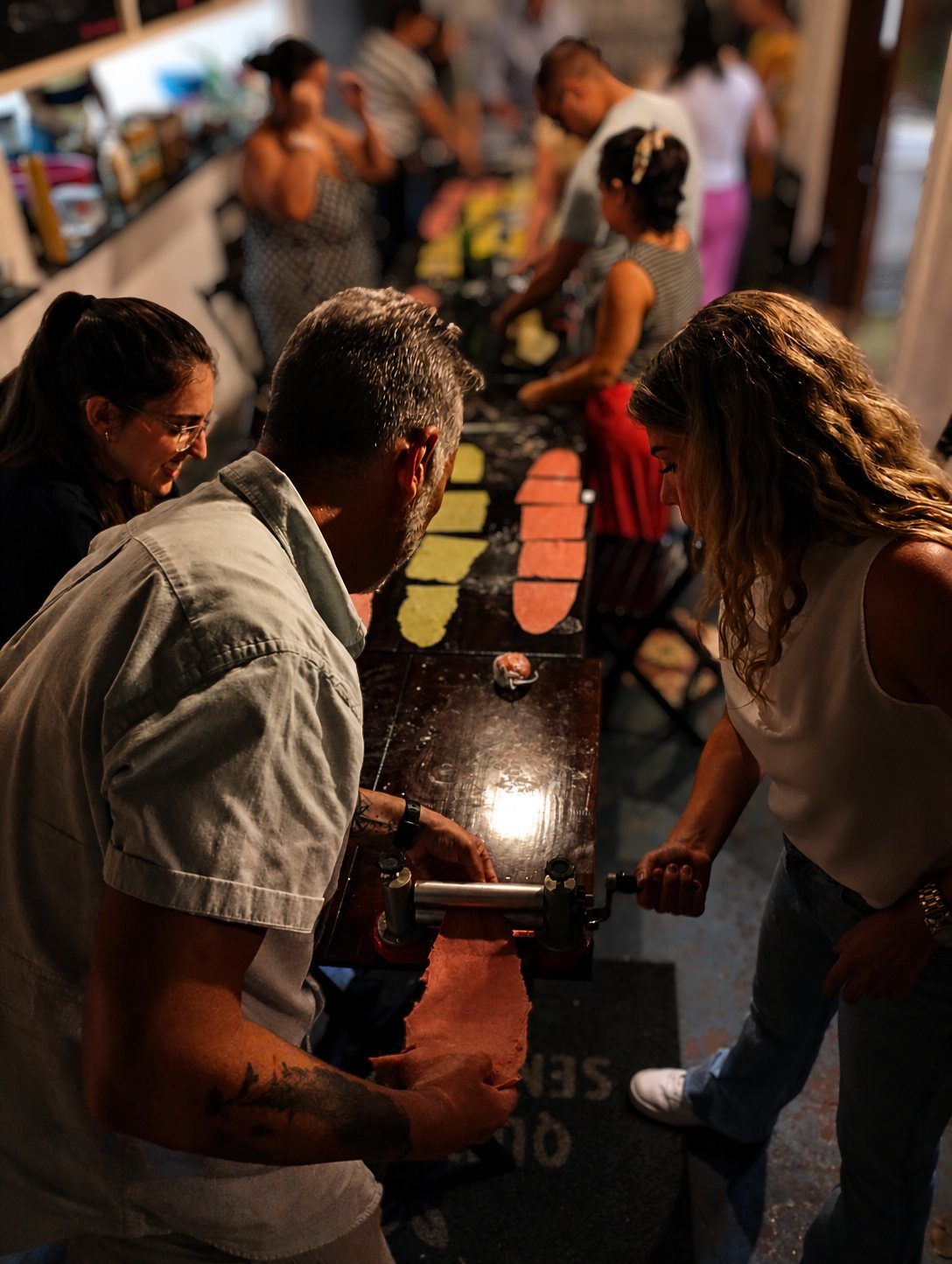 Participantes abrindo massa no cilindro
